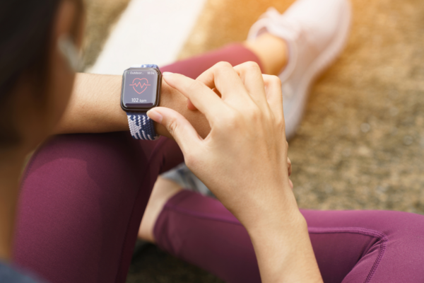 Woman exercising while checking her smartwatch for heart rate data