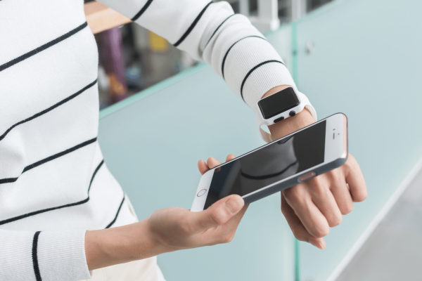 Woman using wearable device and smartphone in a clinical trial