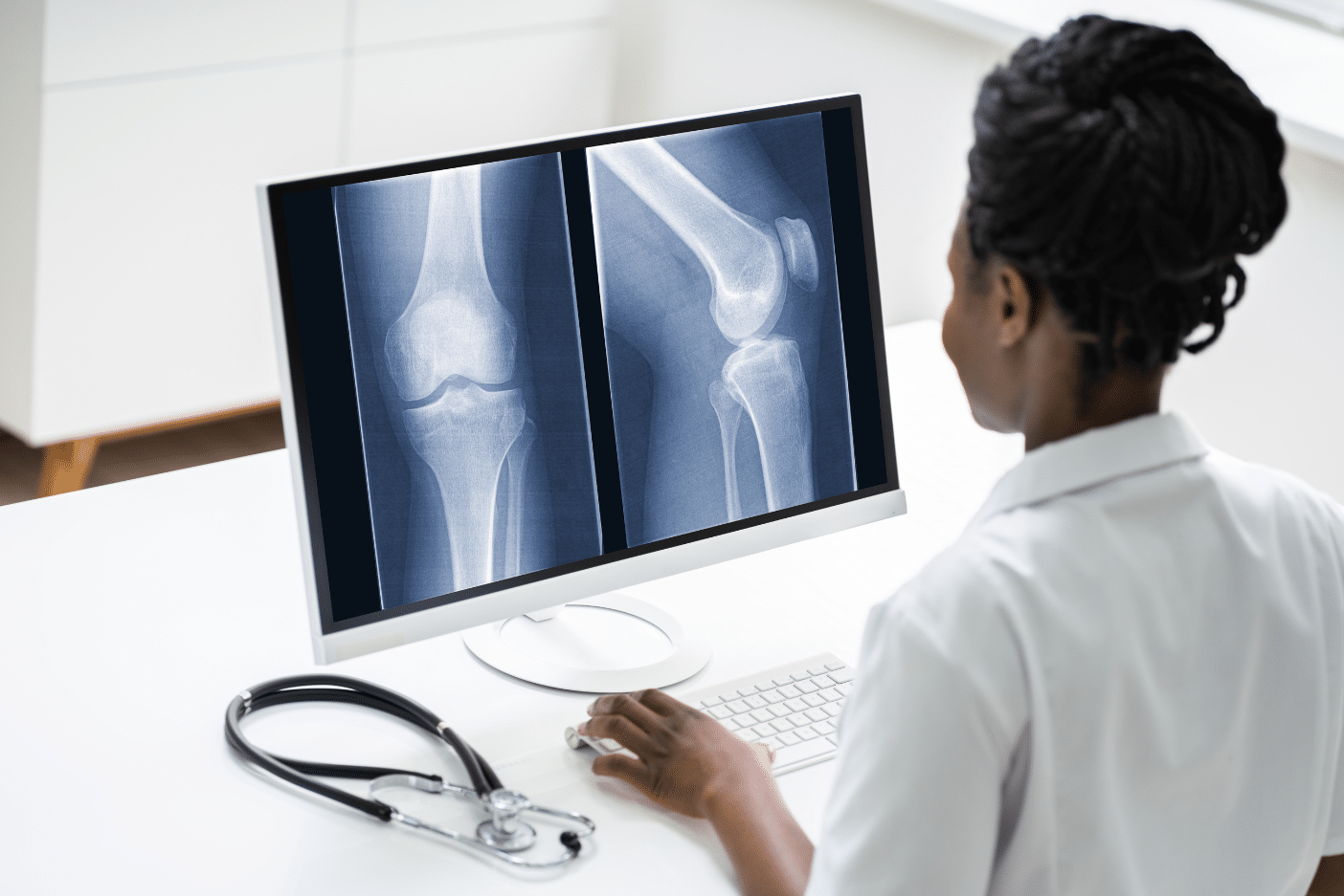 Medical professional at computer looking at x rays in a DICOM viewer