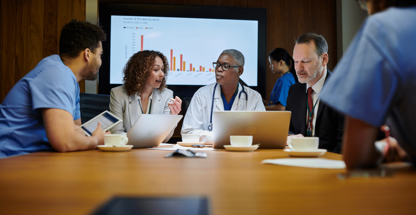 Research team working at conference table with laptops and tablets