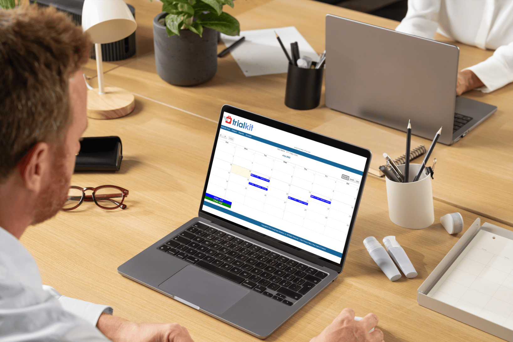 man using TrialKit Engage on laptop to manage visits
